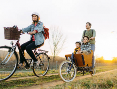 Personne roulant sur un vélo cargo avec ses 2 enfants
